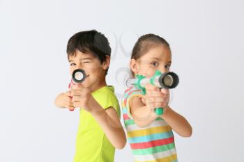 Cute little children with ball guns on light background�