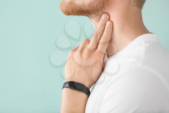 Man checking his pulse on color background, closeup�