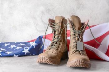 Military boots and USA flag on table�