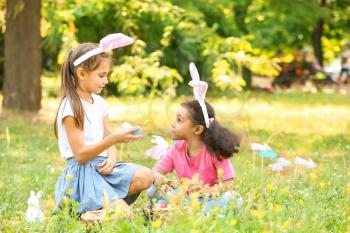 Little children gathering Easter eggs in park�