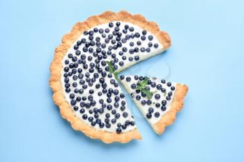 Tasty bilberry pie on color background�