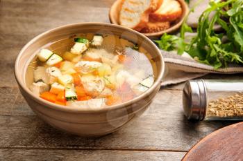 Bowl of tasty soup on wooden table�