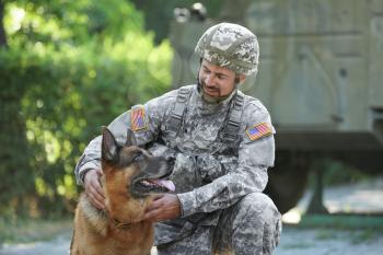 Soldier with military working dog outdoors�