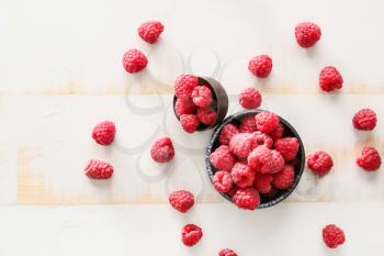 Bowls with fresh raspberries on white table�