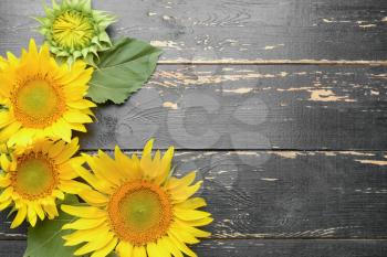 Beautiful sunflowers on wooden background�