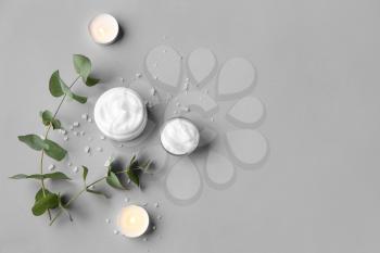Composition with body cream and candles on grey background�