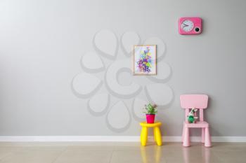 Chair and table near light wall in modern children's room�