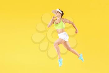 Running female tennis player on color background�