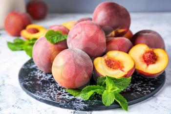 Board with tasty peaches on table�