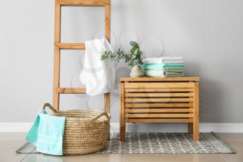 Basket and wooden box with soft towels in room�