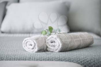Rolled clean towels on bed�