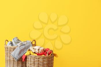 Baskets with dirty laundry on color background�