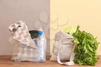 Garbage with fresh vegetables in different bags on wooden table�