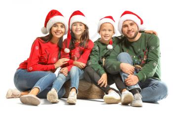 Happy family in Christmas sweaters and Santa hats on white background�