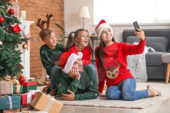 Happy family taking selfie at home on Christmas eve�