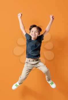 Jumping little boy on color background�