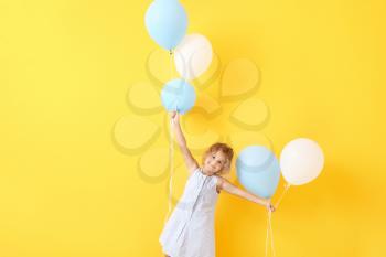 Little girl with balloons on color background�