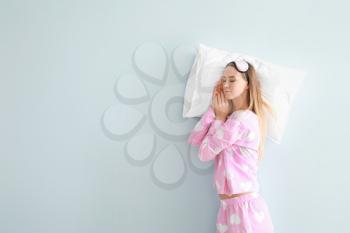 Sleeping young woman on color background�