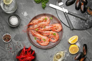 Plate with tasty shrimps, crayfish and mussels on grey background�