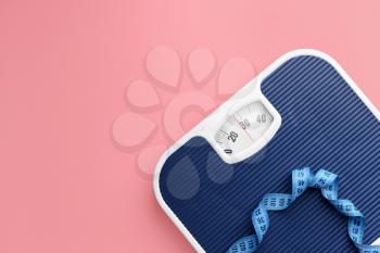 Scales and measuring tape on color background. Weight loss concept�