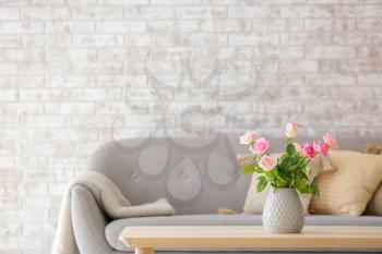 Beautiful rose flowers in vase on table in room�