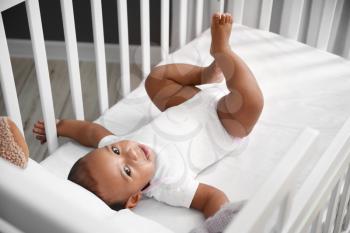 Cute little African-American baby in crib�