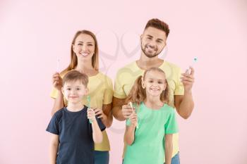 Portrait of family with toothbrushes on color background�