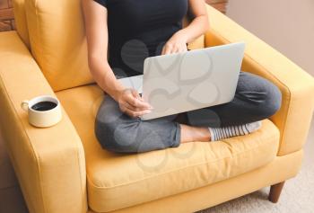 Young woman working on laptop at home�