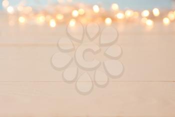 Wooden table and blurred Christmas lights, closeup�