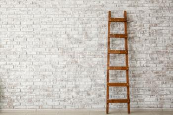 Wooden ladder near brick wall�