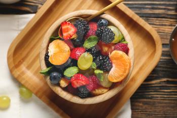 Bowl with tasty fruit salad on table�
