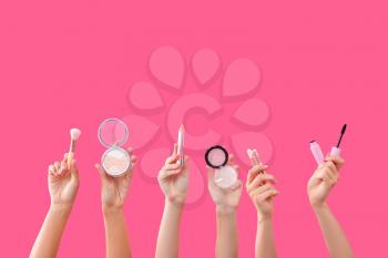 Many hands with decorative cosmetics on color background�
