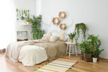 Stylish interior of bedroom with green houseplants�