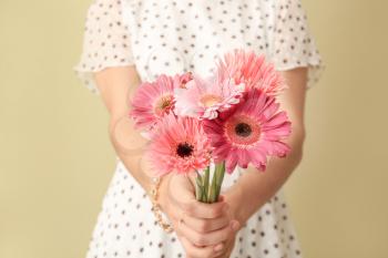 Woman with bouquet of beautiful flowers on color background�