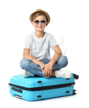 Cute little boy with suitcase on white background�