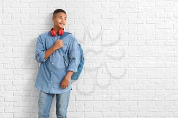 Portrait of African-American teenage schoolboy on brick background�