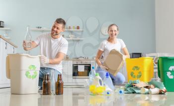 Couple sorting garbage at home. Concept of recycling�