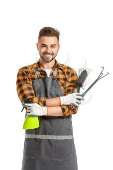 Handsome male gardener with tools on white background�