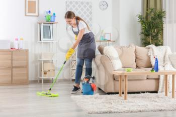 Female janitor mopping floor in room�