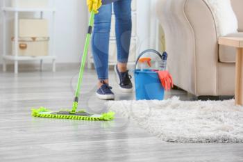 Female janitor mopping floor in room�