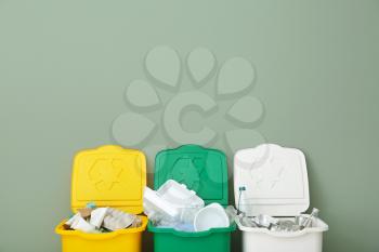 Containers with different types of garbage near color wall. Recycling concept�