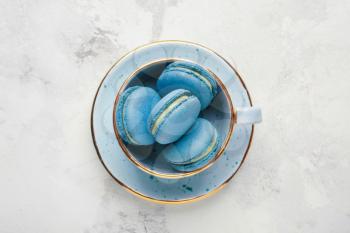 Cup with tasty macarons on white background�