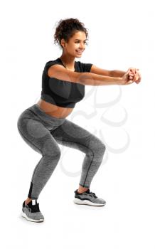 Sporty African-American woman training against white background�