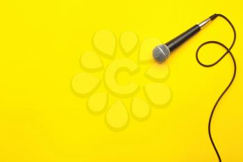 Modern microphone on color background�