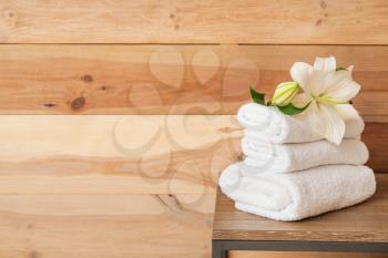 Clean towels on table near wooden wall�