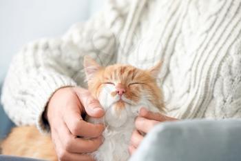 Man stroking cute cat at home�