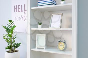 Shelving unit with decor near white wall�