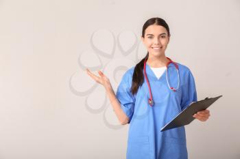 Female medical student showing something on light background�