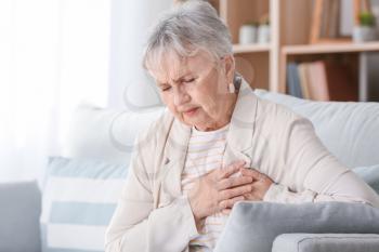Senior woman suffering from heart attack at home�