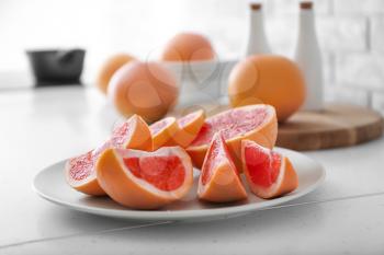 Plate with fresh cut grapefruit on table�